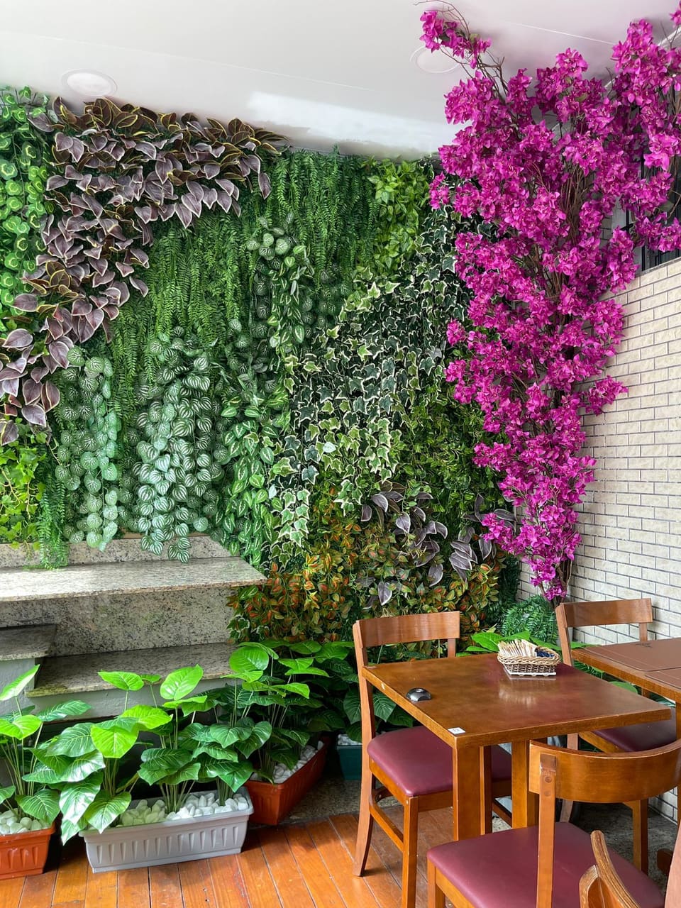 Jardim vertical artificial com primavera roxa em salão de restaurante